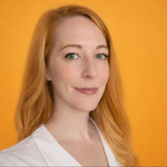 Gwen Betts, red hair over one shoulder, a slight smile, in a white top.